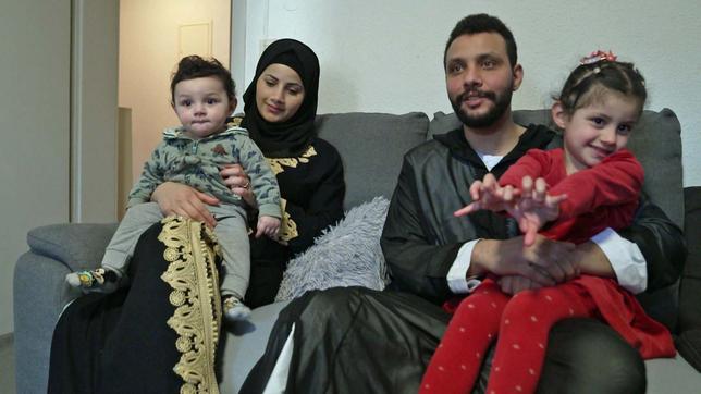 Ehepaar mit zwei kleinen Kindern auf der Couch