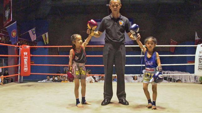 Ringrichter mit zwei Kindern im Boxring