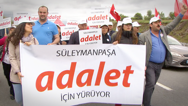 Menschen mit Plakaten mit der Aufschrift "adalet" (Gerechtigkeit)