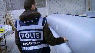 Polizist kontrolliert Schlauchboot-Werkstatt