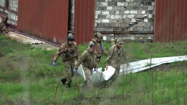 Soldaten tragen Leichensack weg