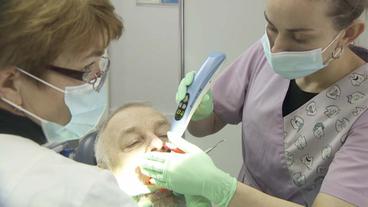 Zahnärztin und Assistentin behandeln Patienten