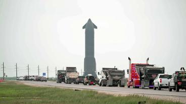 Autos auf Straße mit Rakete im Hintergrund