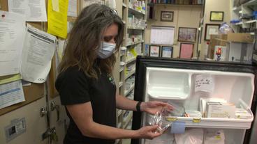 Frau hält Packung mit Impfdosen in der Hand
