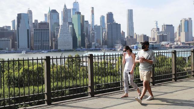 Spaziergänger mit Maske vor der Silhouette von New York