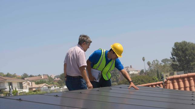 Arbeiter installieren Solaranlage auf Dach