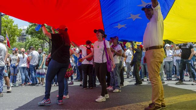 Demonstranten mit große venezolanischer Fahne 