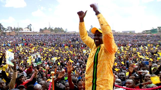Ein Mann in gelber Kleidung lässt sich bei einer Wahlkampfveranstaltung von einer Menschenmenge feiern.