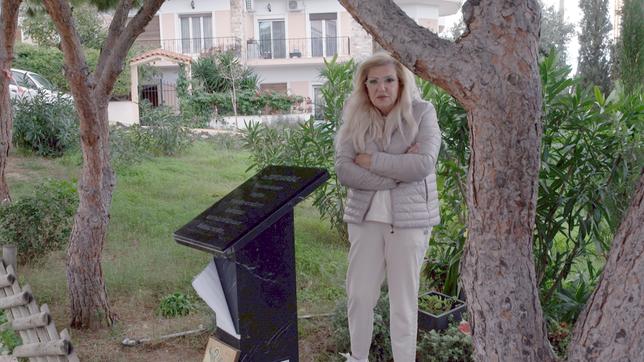 Ein Frau in einer Grünanlage an einem Denkmal