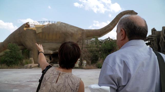 Ein Frau und ein Mann vor einer großen Dinosaurierfigur