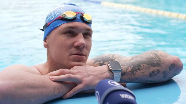 Ein Mann vor einem Mikrofon in einem Schwimmbecken