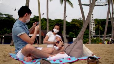 Paar mit Kind am Strand in Singapur.