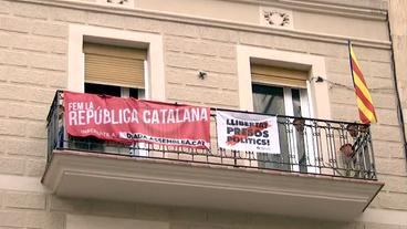 Eine katalonische Flagge und Spruchbänder hängen an einem Balkon