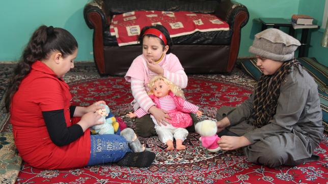 Fatima und ihre Schwestern sitzen auf dem Boden.