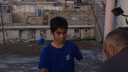 Yussufs Eltern haben sich getrennt. Der Junge lebt allein mit seiner Mutter in einem vierstöckigen Haus. Außer den beiden leben noch fünf Familien in den Nebengebäuden. Alle anderen Bewohner haben die einst so belebte Shuhada Straße verlassen. 