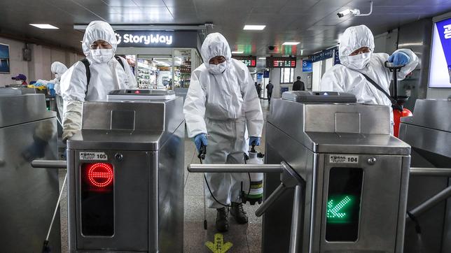 Arbeiter in Schutzkleidung versprühen Desinfektionsmittel als Vorsichtsmaßnahme gegen das neue Coronavirus eine U-Bahn-Station in Seoul, Südkorea. 