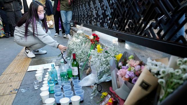 Eine Frau legt einen Blumenstrauß zum Gedenken an die Opfer der tödlichen Massenpanik ab.