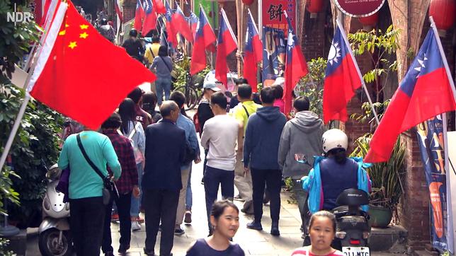 Chinesische und taiwanesische Flaggen in einer Einkaufsstraße.