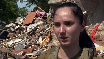 Eine Soldatin vor Trümmern im Interview.