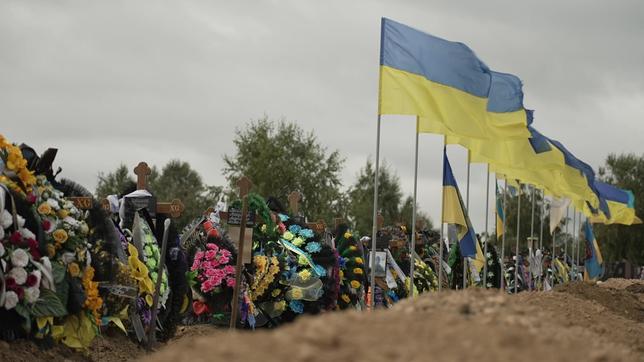 Ukrainische Flaggen neben Gedenkkränzen