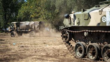 Ein Panzer und ein Truck in einem Militärcamp in der Ostukraine