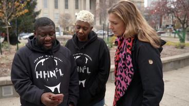 Korrespondentin Kerstin Klein schaut mit Nyree und Antonio Taylor auf ein Handy.