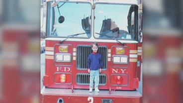 Brook Peters als Kind vor einem Feuerwehrauto
