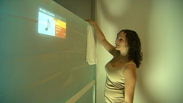 Junge Frau steht vor einer  Projektionsfläche in einer Duschwandkabine