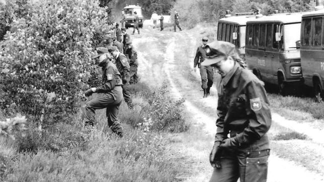 Bild: dpa 30.07.1989: Polizeibeamte einer Hundertschaft durchsuchen den Wald in der Göhrde nach Spuren des Täters, der ein Hamburger Ehepaar getötet hatte.