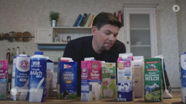 Tim Mälzer vor Milchpackungen