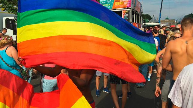 Mann schwingt Regenbogenflagge auf Gay-Pride-Festival in Berlin.