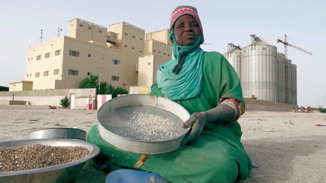 Bild: ThurnFilm/William Dubas/Mamdou Diop Frauen sieben Weizenkörner aus dem Sand am Boden.
