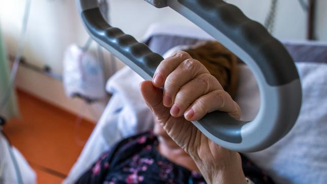 Eine Patientin liegt im Pflegebett auf einer Palliativ-Station.