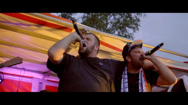 Bild: NDR/Eichholz Film GmbH Bei einem Open-Air Konzert in Anklam im Sommer 2016 steht Monchi gemeinsam mit dem Künstler Marteria auf der Bühne. Sie singen Arm in Arm mit nach oben gerichteten Mikros.
