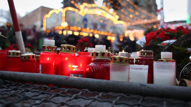 Bild: picture alliance/Wolfram Steinberg Kerzen und und Blumen als Zeichen der Trauer, aufgenommen am 26.12.2016 auf dem Weihnachtsmarkt an der Gedächtniskirche am Breitscheidplatz in Berlin.