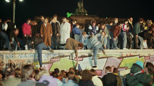 Berlin in der Nacht vom 9. November 1989: Berliner aus beiden Teilen der Stadt stürmen die Mauer am Brandenburger Tor. 