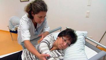 Bild: WDR/Kilimann TV Produktion Pflegetrainerin Beate Peddinghaus (l) zeigt Brigitte Naumann, wie diese einen pflegebedürftigen Menschen im Bett ohne Schmerzen umdrehen kann
