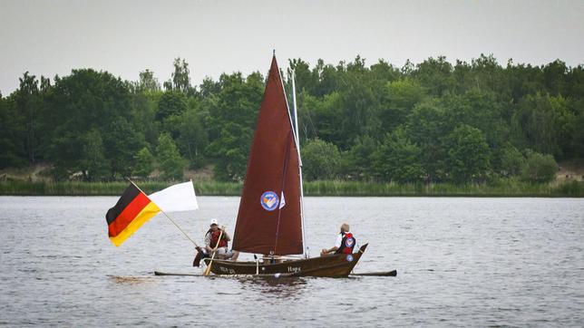 Bild: MDR/timeline Ein asiatisches Fischerboot auf dem Bergwitzsee. Da staunen die einheimischen Segler vom Verein „Klar zur Wende“ und helfen Frank, das Auslegerboot zu Wasser zu lassen. Frank hat das Holzboot geschenkt bekommen und will jetzt das Segeln lernen.