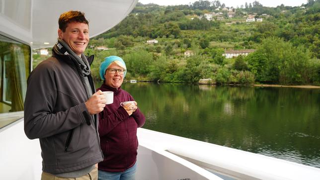 Bild: BR/Bewegte Zeiten/Deborah Stoeckle Alex und Alex genießen den frühen Morgen am Deck. Sie sind extra früh ausfgestanden und trinken Kaffee.