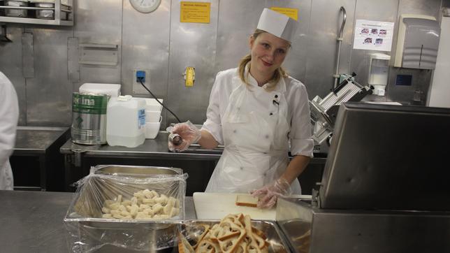 Küchenpraktikantin Elisabeth sticht Toastbrot in der Küche aus, ihre erste Aufgabe in der Bordküche der "Grand Lady".