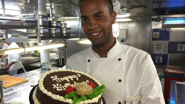 Küchenpraktikant Steven Igbinidou ist 21 Jahre alt geworden und hat von seiner Küchencrew eine Torte gebacken bekommen. Über die freut er sich sehr.