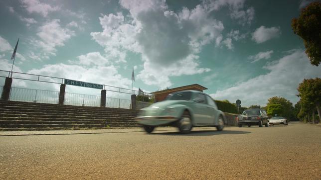 Bild: beckground tv GmbH Autos fahren am Eingang der Sportschule in Malente vorbei