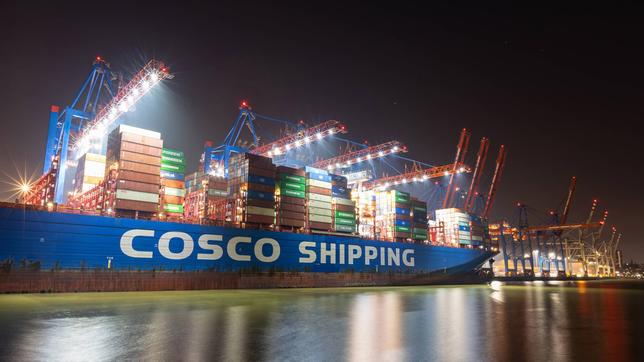 Das Containerschiff Cosco Shipping Aries des chinesischen Unternehmens Cosco China Ocean Shipping Company liegt in der Nacht am Container-Terminal Tollerort der HHLA im Hamburger Hafen.