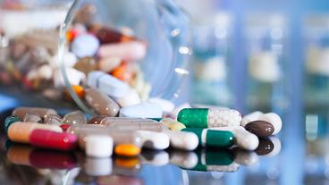 Bild: fotolia.com/motorlka Verschiedene Tabletten und Kapseln liegen auf einem Tisch.