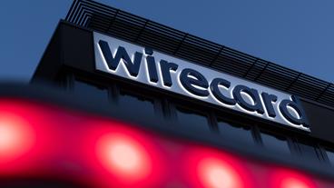 Bild: dpa/Peter Kneffel Das erleuchtete Firmenschild von Wirecard bei Nacht.