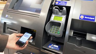 An einem Automaten wird mit einem Smartphone gezahlt