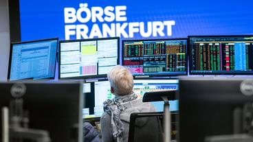 Bild: picture alliance/dpa/Frank Rumpenhorst Eine Händlerin sitzt im Handelssaal der Frankfurter Börse.