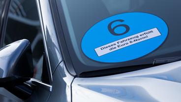 Bild: picture alliance / Rolf Vennenbernd/dpa Ein Autohersteller wirbt mit einer überdimensionalen blauen Plakette dafür, dass das Fahrzeug die «Euro 6»-Norm erfüllt.