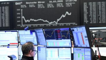 Bild: dpa Bildfunk/Arne Dedert Mann sitzt vor zahlreichen Monitoren an der Börse