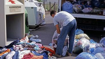 Bild: Imago Images/Imagebrocker/Theissen Ein Mann entleert einen Kleidercontainer